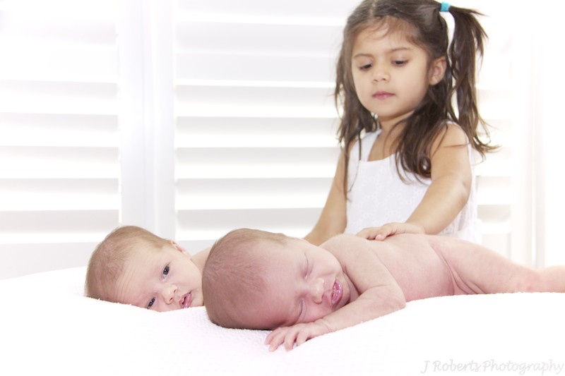 big sister patting newborn twins - newborn portrait photography sydney